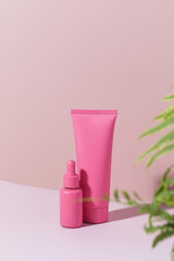 Mockup of pink containers for cosmetics, cream, serum, gel on a pink background. Copy space.