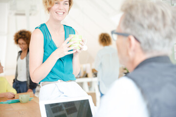 Obraz premium Man and woman sitting in office,smiling and talking