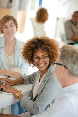 Fototapeta premium Three office workers talking at desk with laptop