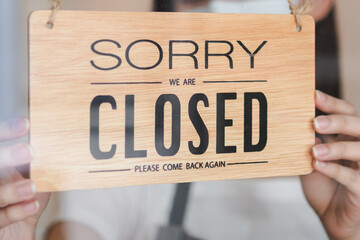Asian young owner retail,coffee shop woman turning sign board to closed with wearing face...