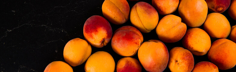 Close-up of fresh.Space for text top view. A group of ripe peaches on dark kitchen table.