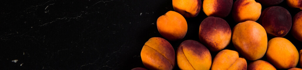 Close-up of fresh.Space for text top view. A group of ripe peaches on dark kitchen table.