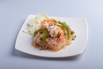 Yum Wan noodles with pork and shrimp in a white plate full focus on top view