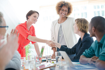 Office workers shaking hands at desk