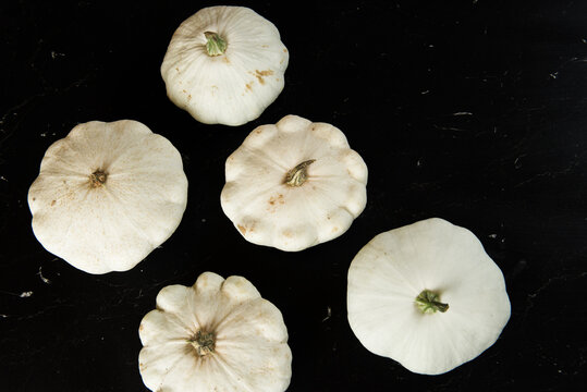 patison pumpkin squashed on dark kitchen table, whole bio raw vegetable brom village gardening