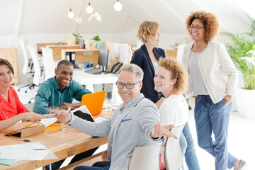 Fototapeta premium Office workers talking and smiling at meeting