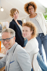 Office workers talking and smiling at meeting