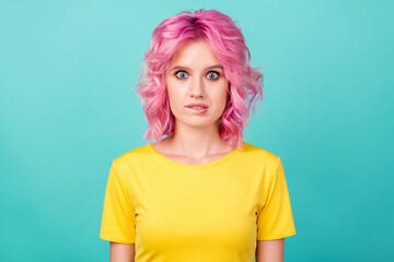 Photo of young nervous pink hairdo lady bite lip wear yellow t-shirt isolated on teal color background