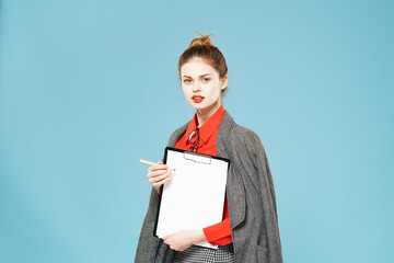 Business woman with a jacket on her shoulders folder in hand working blue background