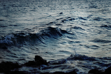 Naklejka premium Dark deep blue sea water with waves in twilight, serene and calming natural water background
