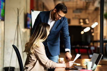Colleagues in office. Businesswoman and businessman discussing work in office. Two friends working together.