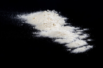 biały proszek na czarnym tle jak kokaina lub mąka