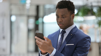 African Businessman using Smartphone in Office