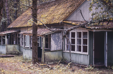 An old wooden abandoned house in the forest with footpaths. One of the structures of the soviet...