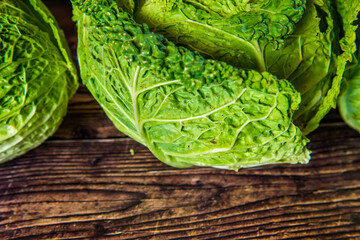 Fresh bio green garden cabbage on rustic wooden background from farm village gardening.
