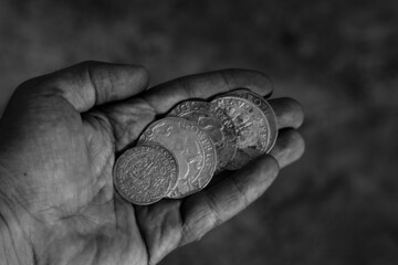 Naklejka premium Vintage coins in hand in black and white