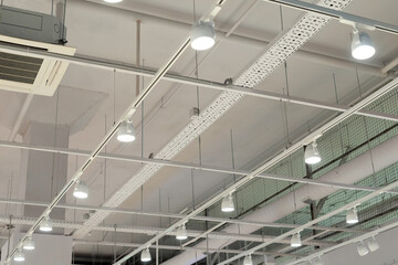 Ceiling with bright lights in a modern warehouse, shopping center building, office or other...