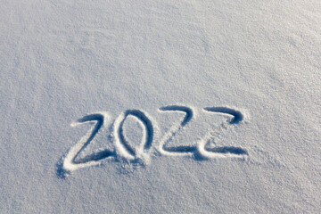 the inscription about the new year 2022 on the snow in winter