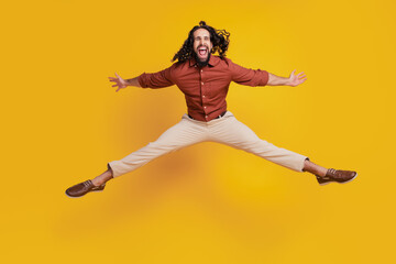 Portrait of crazy careless guy jump make star shape on yellow background