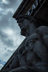 Statue of thinking man in a rainy day next to the palace of culture in warsaw