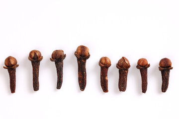 Fragrant dry clove but spice macro closeup top view in a row border frame on white background