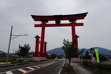 くぐる自動車が小さく見える弥彦神社の大鳥居／日本新潟県西蒲原郡
