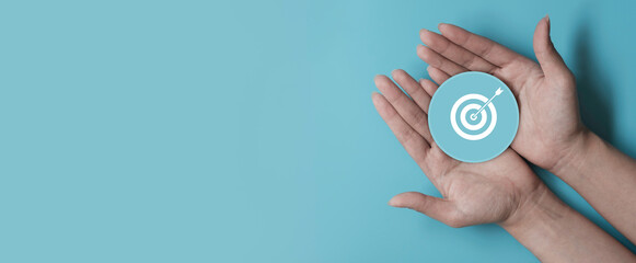 Hand holding blue paper cut with target icon, business strategy, Action plan, Goal and target,...