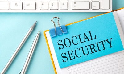 SOCIAL SECURITY text on sticker on the blue background with pen and keyboard