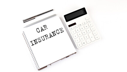 Notepad with text CAR INSURANCE with calculator and pen. White background. Business concept