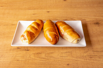 Typical Venezuelan breakfast bun, cachito, stuffed with ham and cheese and baked with egg touches on the top