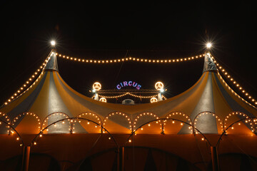 A circus tent at night with its colorful lights on - obrazy, fototapety, plakaty