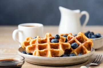 Belgian waffles with blueberries on a wooden table. Breakfast food