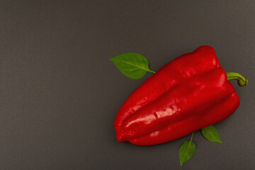 Giant red bell pepper isolated on black stone background