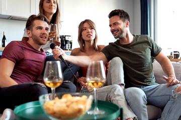Friends enjoying karaoke at house
