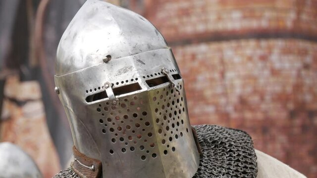 Medieval warrior knight in iron armor and helmet, head close up view