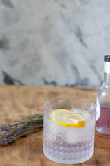 lavender lemonade with ice in a low glass glass stands on a table