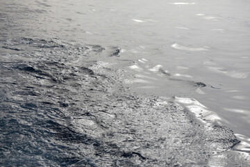Sea background with waves, reflections and copy space.