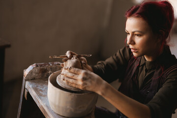 Young woman sculptor artist creating a bust sculpture