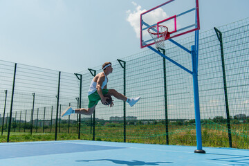 Side view of sportsman playing streetball on outdoor playground