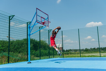 African american player jumping with basketball ball under hoop