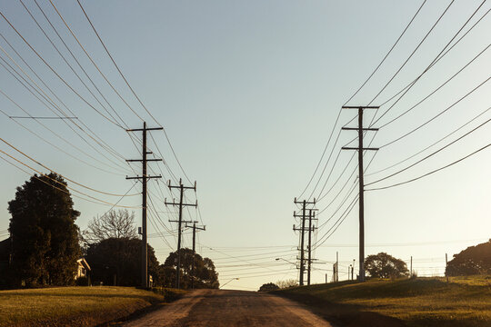 Electric poles and cables along country road.