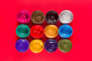 bottle of mixed color paints isolated on red background