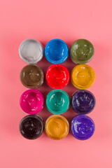 bottle of mixed color paints isolated on pink background