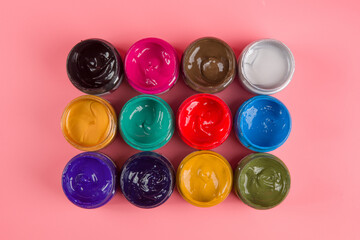 bottle of mixed color paints isolated on pink background