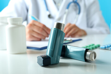 Inhalers against female doctor sitting at the table and writing