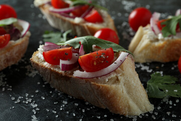Delicious bruschetta snacks on black smokey background