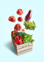 Fresh vegetables flying in a wooden box isolated from blue background