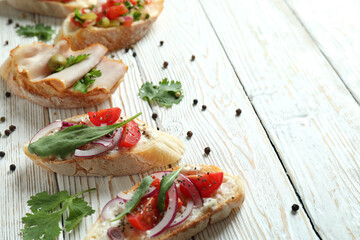 Delicious italian snacks bruschetta on white wooden background