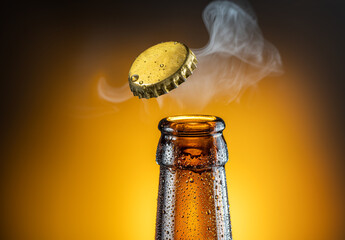 Opening of cold beer bottle - gas output and bottle cap in the air. Isolated on a yellow background. - 454114469