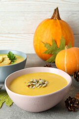 Concept of tasty food with pumpkin soup on gray textured table